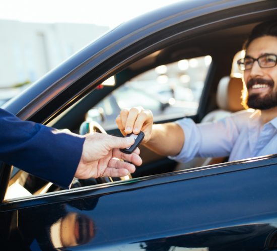 Young handsome businessman buying car